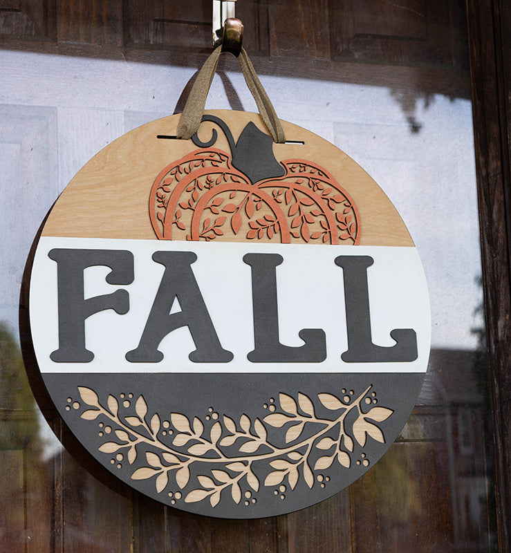 Round wooden door hanger with pumpkin design and 'FALL' text from Thistlewood Creations